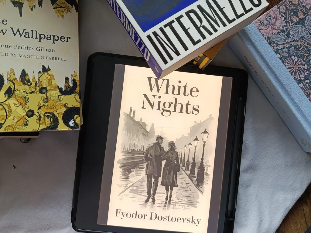 A photo of White Nights by Fyodor Dostoevsky open on Kindle Scribe, with some books in the background as decoration