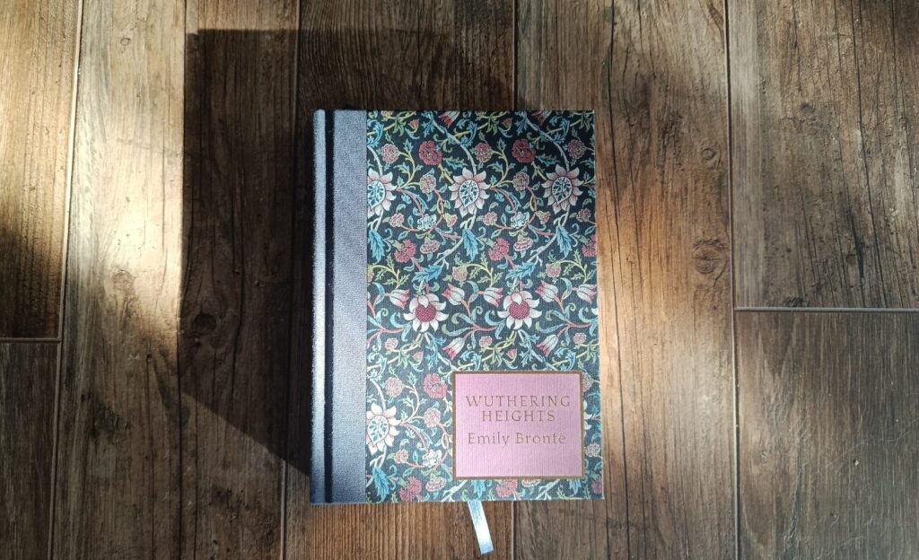 a photo of a wordsworth heritage edition of wuthering heights by emily bronte, pictured against a wood background